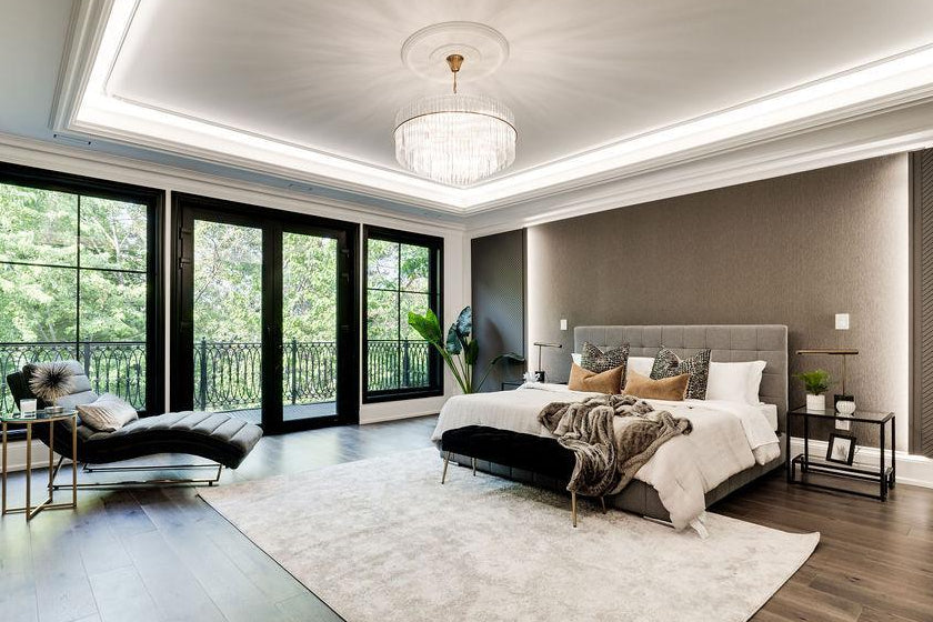 Modern bedroom with large windows, a bed, and decorative pillows.